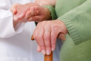 Mani di un anziano e di un'infermiera