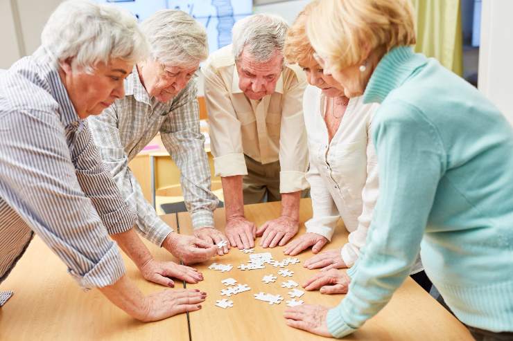 Gruppo di anziani che fanno un puzzle