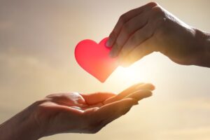 Mano consegna un cuore a un'altra mano