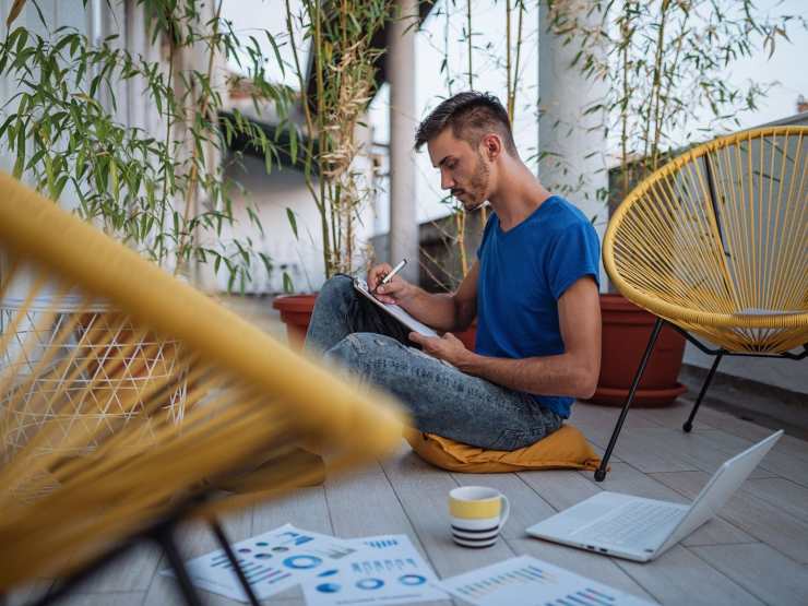 uomo al balcone scrive documenti