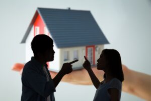 Sagoma di fratello e sorella che litigano e una casa sullo sfondo