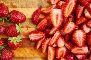 Fragole intere e tagliate su un tagliere