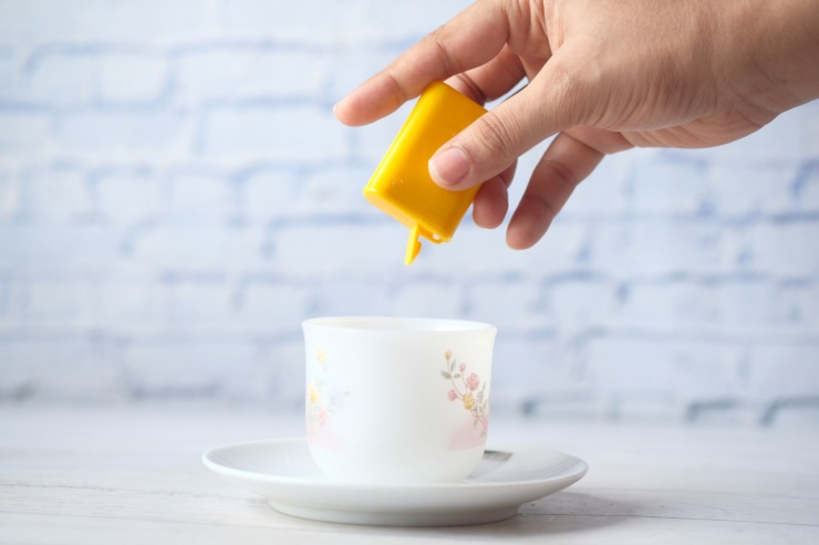 Persona che mette il dolcificante nel caffè