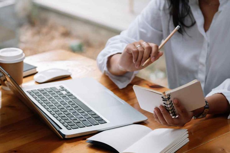 Persona al computer con un taccuino