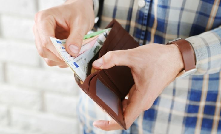 Uomo che estrae banconote dal portafoglio