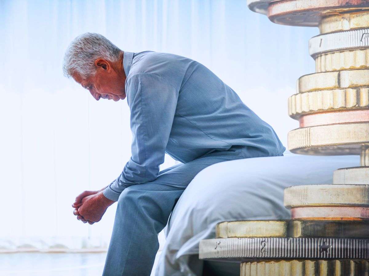 sfondo anziano seduto e monete euro impilate