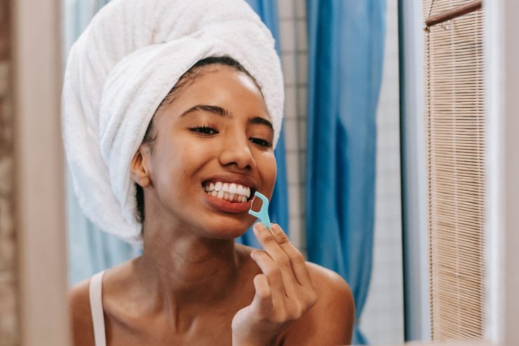 Ragazza si pulisce i denti con lo scovolino