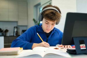 Ragazzo studia con cuffie e pc