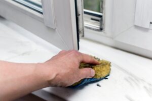 Uomo che pulisce davanzale finestra bagno