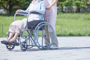 uomo che spinge disabile in carrozina