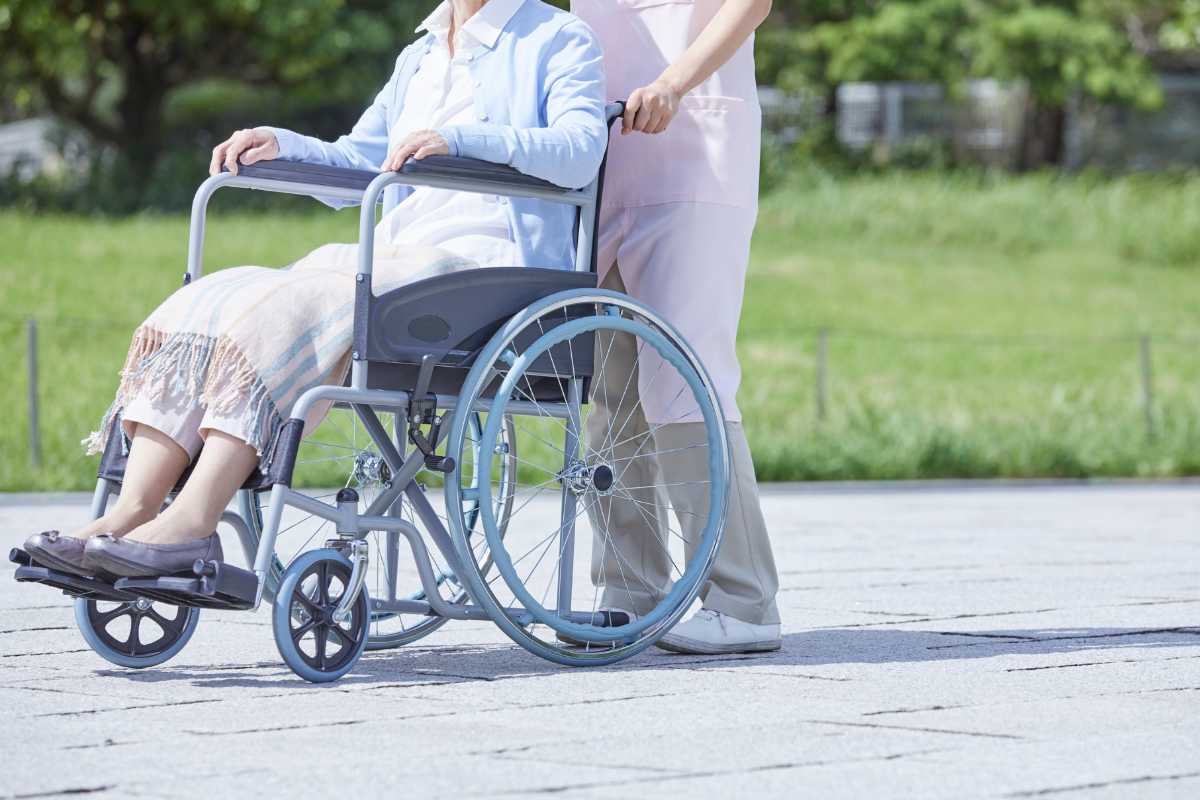 uomo che spinge disabile in carrozina