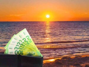 sfondo tramonto su mare e portafoglio con banconote 100 euro