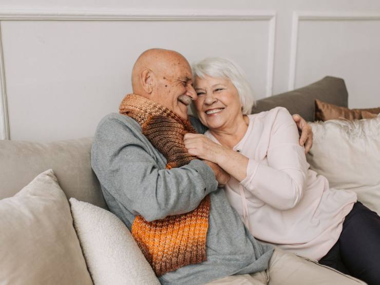 Anziani sorridenti su divano