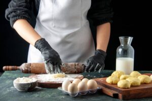 pasticcere che lavora un impasto con il mattarello