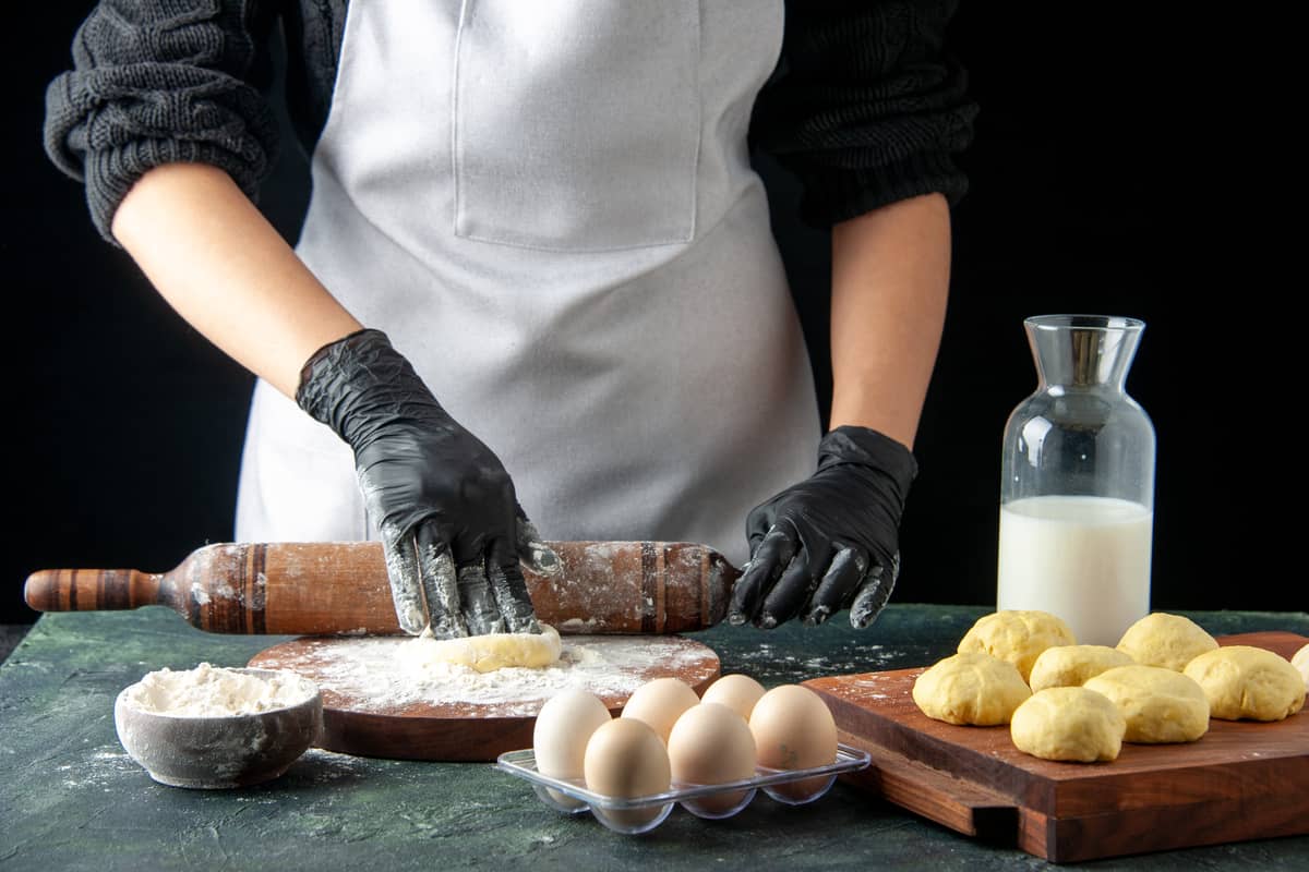 pasticcere che lavora un impasto con il mattarello