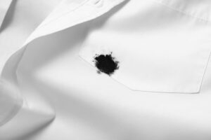 macchia inchiostro nera su camicia bianca