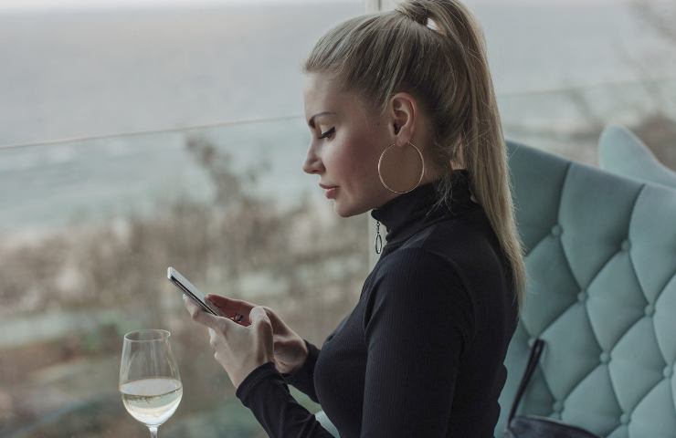 donna usa il cellulare al ristorante