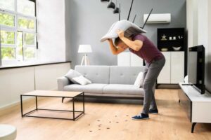 uomo con cuscino che schiaccia scarafaggi