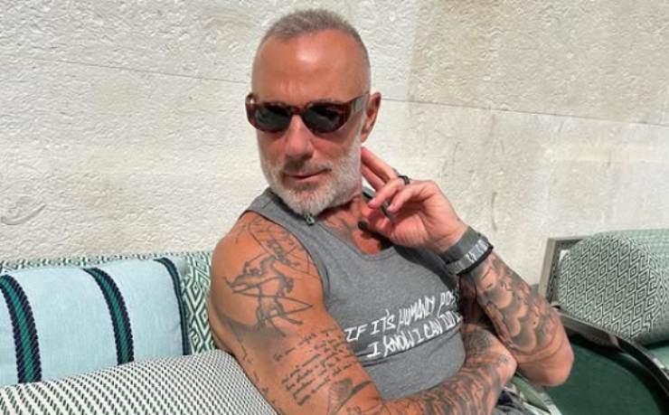 gianluca vacchi seduto con una canotta e gli occhiali da sole
