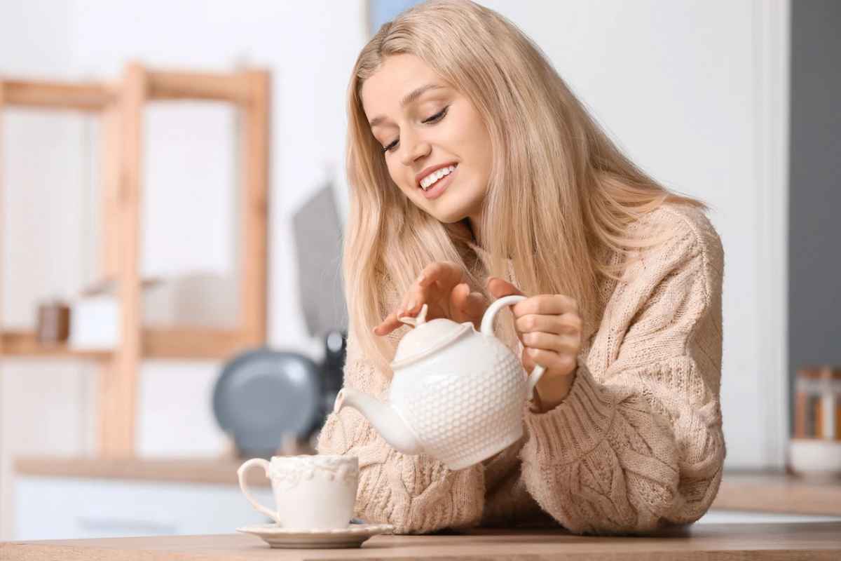 Donna che versa bevanda in una tazza