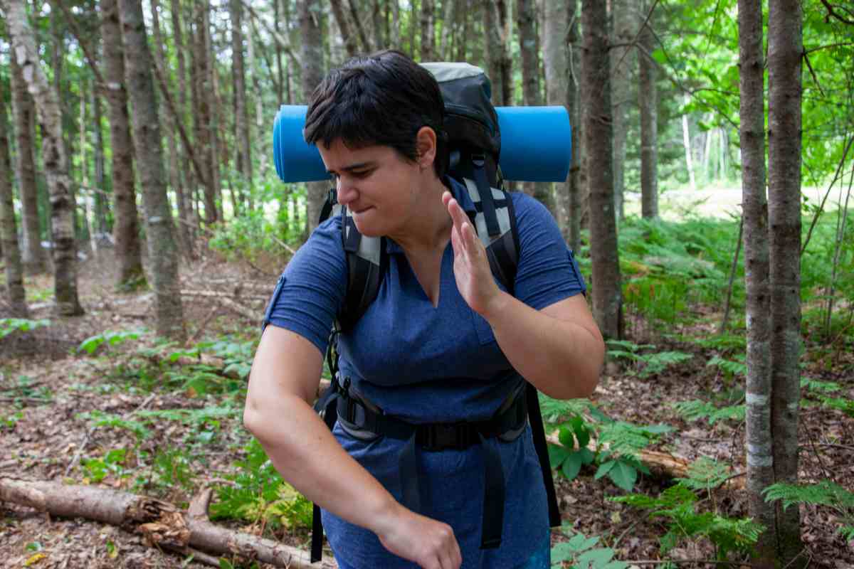 Donna che allontana insettp dal braccio