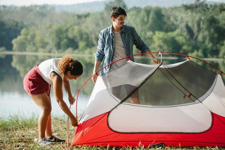 Coppia che monta una tenda da campeggio