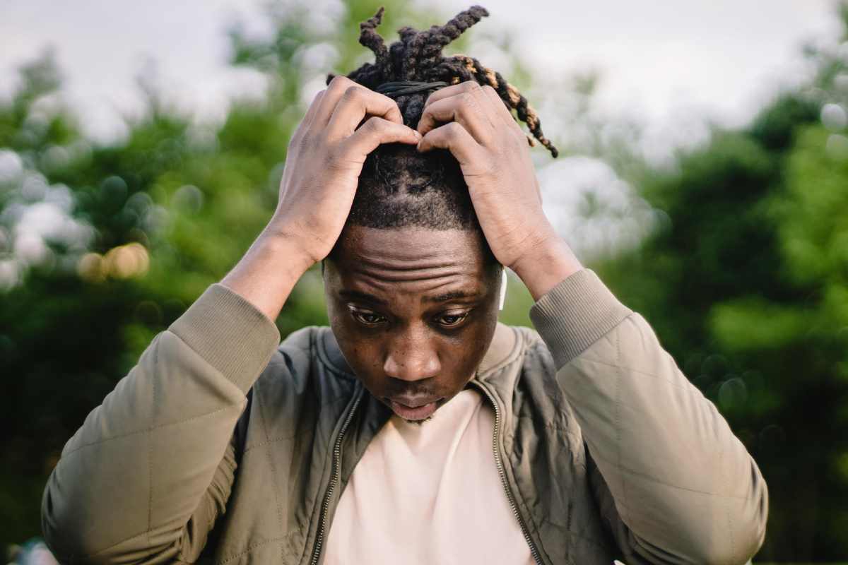 Ragazzo con le mani nei capelli