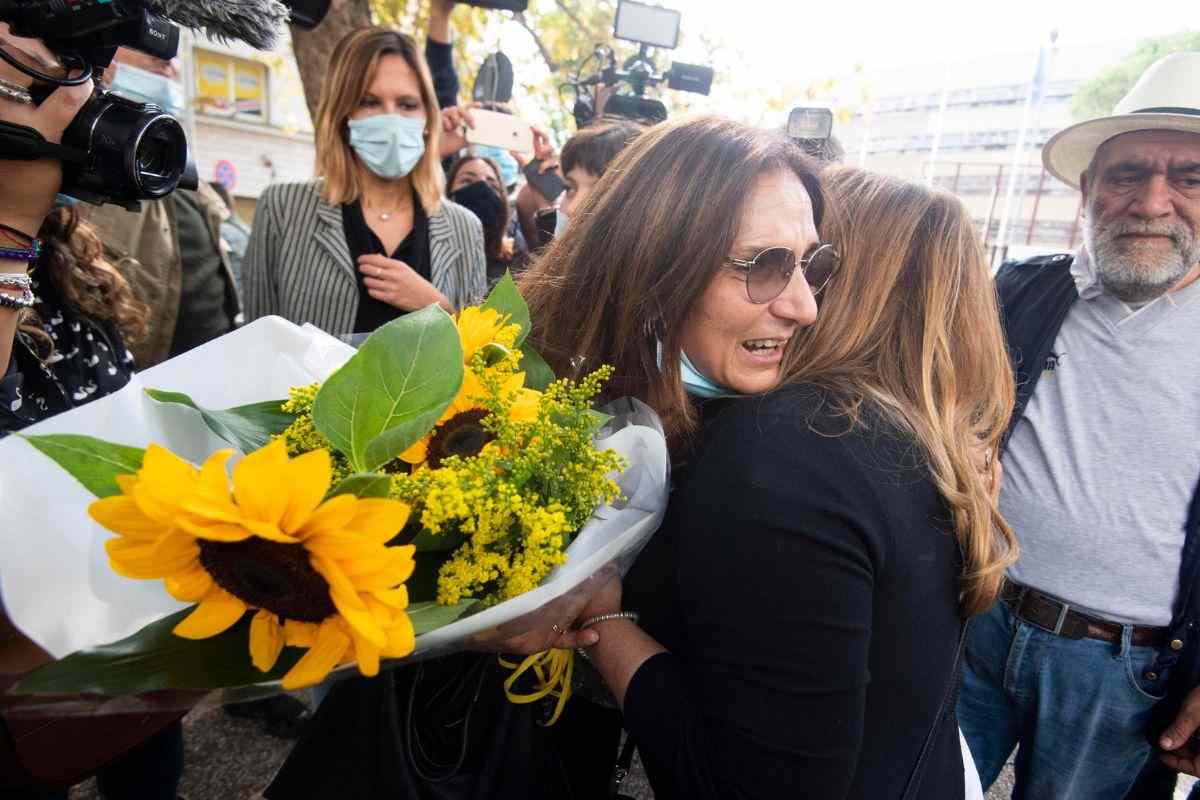 Marina Conte che abbraccia una donna con fiori in mano