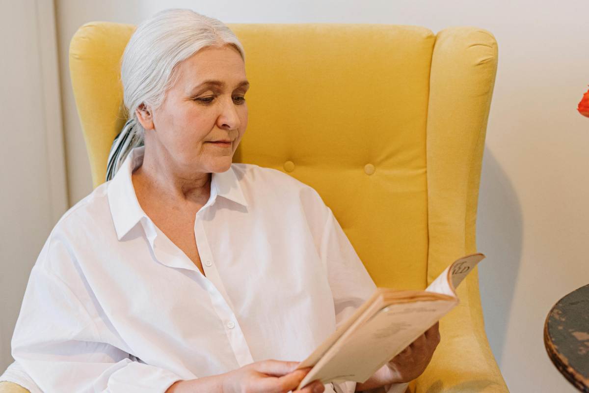 Una donna anziana che legge un libro