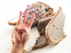 sfondo con pane secco e simbolo 3 con le dita
