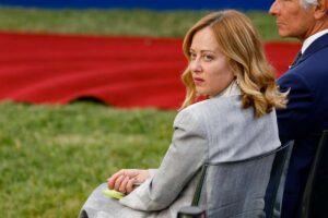 il premier giorgia meloni seduta su una sedia