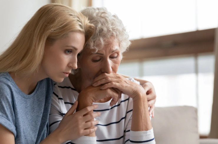 donna giovane che abbraccia una donna donna anziana triste 