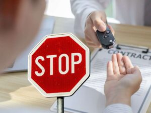 sfondo scambio chiavi auto e cartello di stop