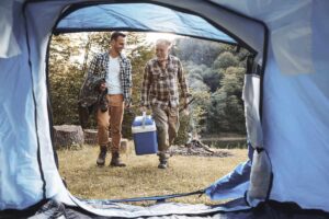 due uomini che camminano verso una tenda da campeggio