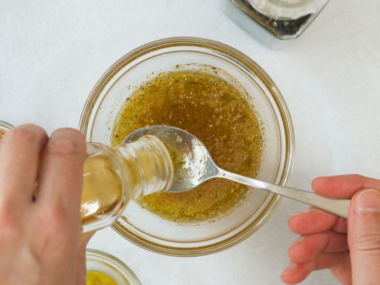 mani versano e mescolano olio in ciotola
