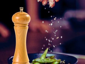 sfondo mano condisce con sale dei fagiolini e saliera