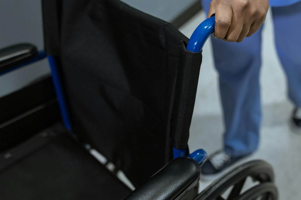 Un infermiere che spinge una sedia a rotelle