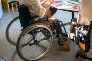 Un ragazzo in sedia a rotelle seduto a un tavolo