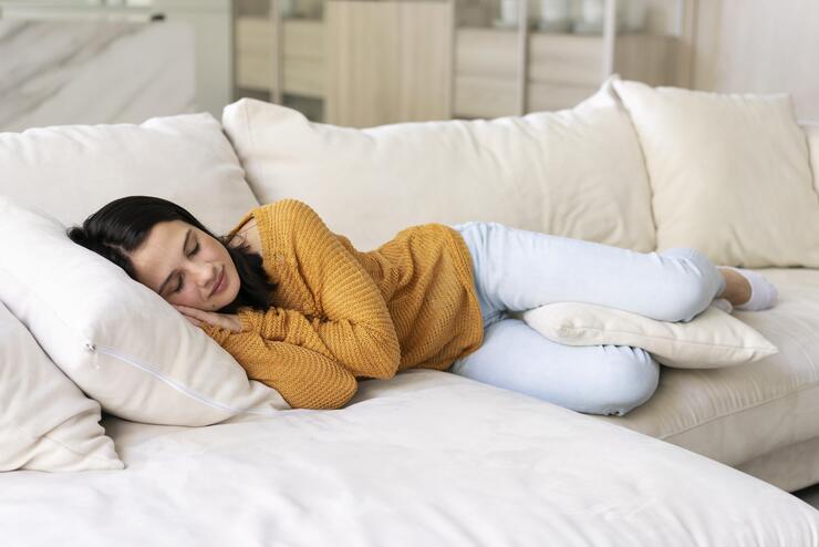 Ragazza che dorme stesa sul divano