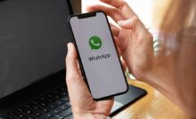 Mani di persona con smartphone e logo whatsapp sullo schermo