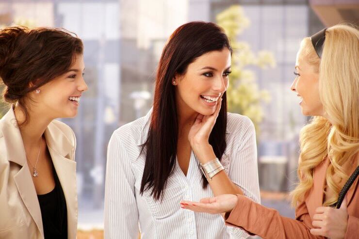 Tre ragazze sorridenti chiacchierano