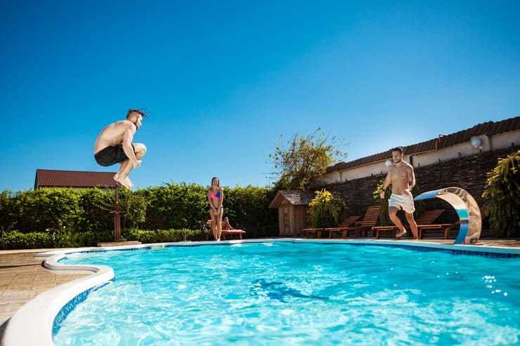 Ragazzi che si tuffano nella piscina del giardino