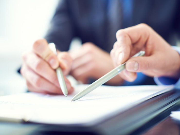 persone indicano documento con penna