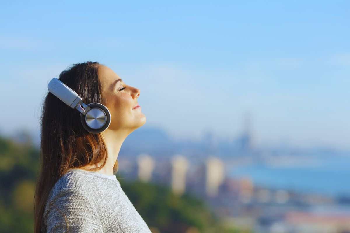 Donna che ascolta musica all'aperto tramite le cuffie