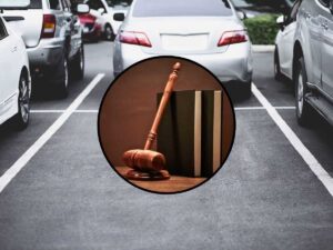 sfondo parcheggio con auto e tondo con martelletto e libri giudice