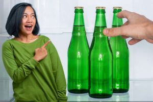 mano prende birre dal frigo e donna che indica