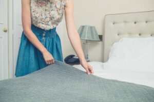 Donna che sistema il letto