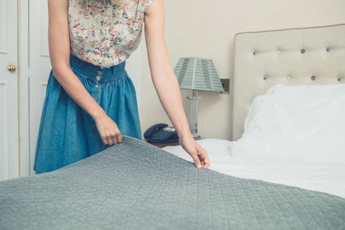 Donna che sistema il letto