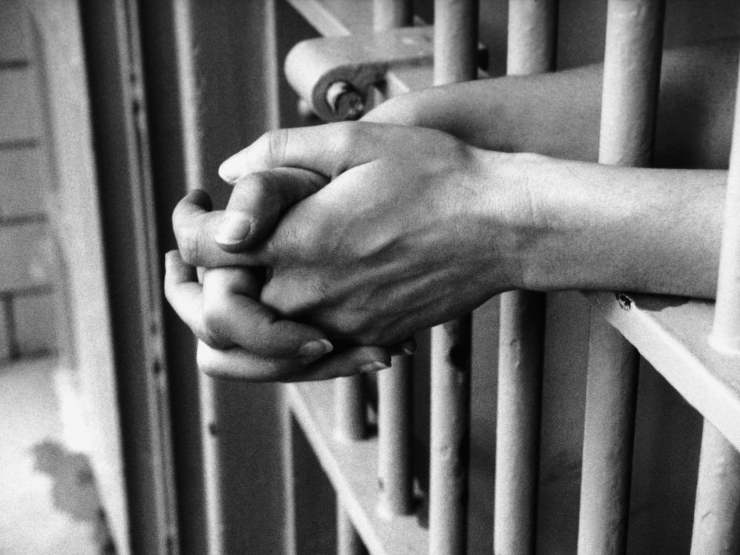 mani che sbucano da cella di carcere