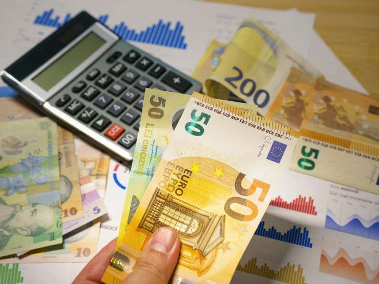 calcolatrice con banconote euro e mano